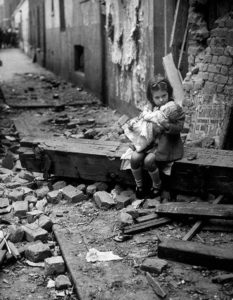Menina se senta em frente à sua casa em ruínas em Londres, em 1940.
