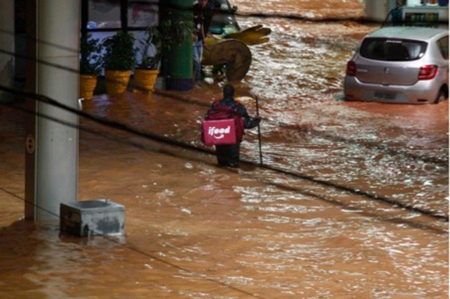 Entregador do iFood enfrentando uma enchente para entregar um pedido. Belo Horizonte, Brasil
