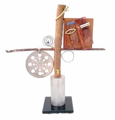 Claudia Seber. Entre a Cruz e a Espada (2019) -36 x 34 x 5 cm (vidro;ferro;pino de pistão;tronco de madeira;cobre;latão;prata;pedras;ralo;espelho) R$ 400,00