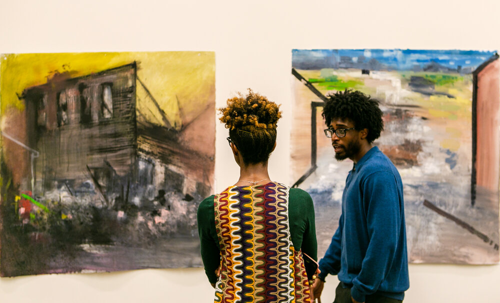 Artista Anthony Patterson falando com uma convidada sobre sua obra de arte durante uma exposição chamada A Perspectiva dos Outros" do "Black On Black Project" em Leland, N.C.  Imagem de Lindy Schoenborn.